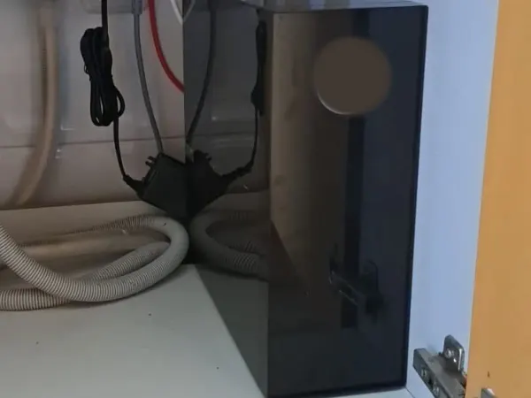 Equipo de ósmosis de flujo directo instalado en un mueble de cocina en Cataluña
